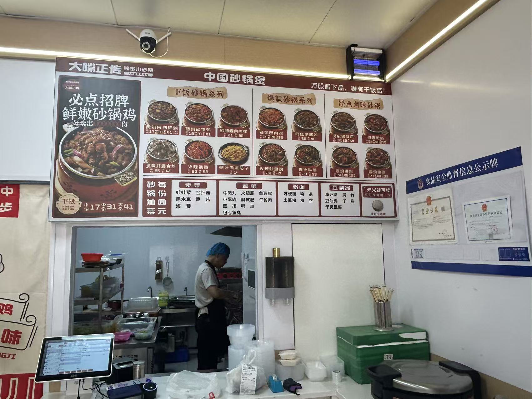 Counter menu board showing chicken pot categories and add-ons