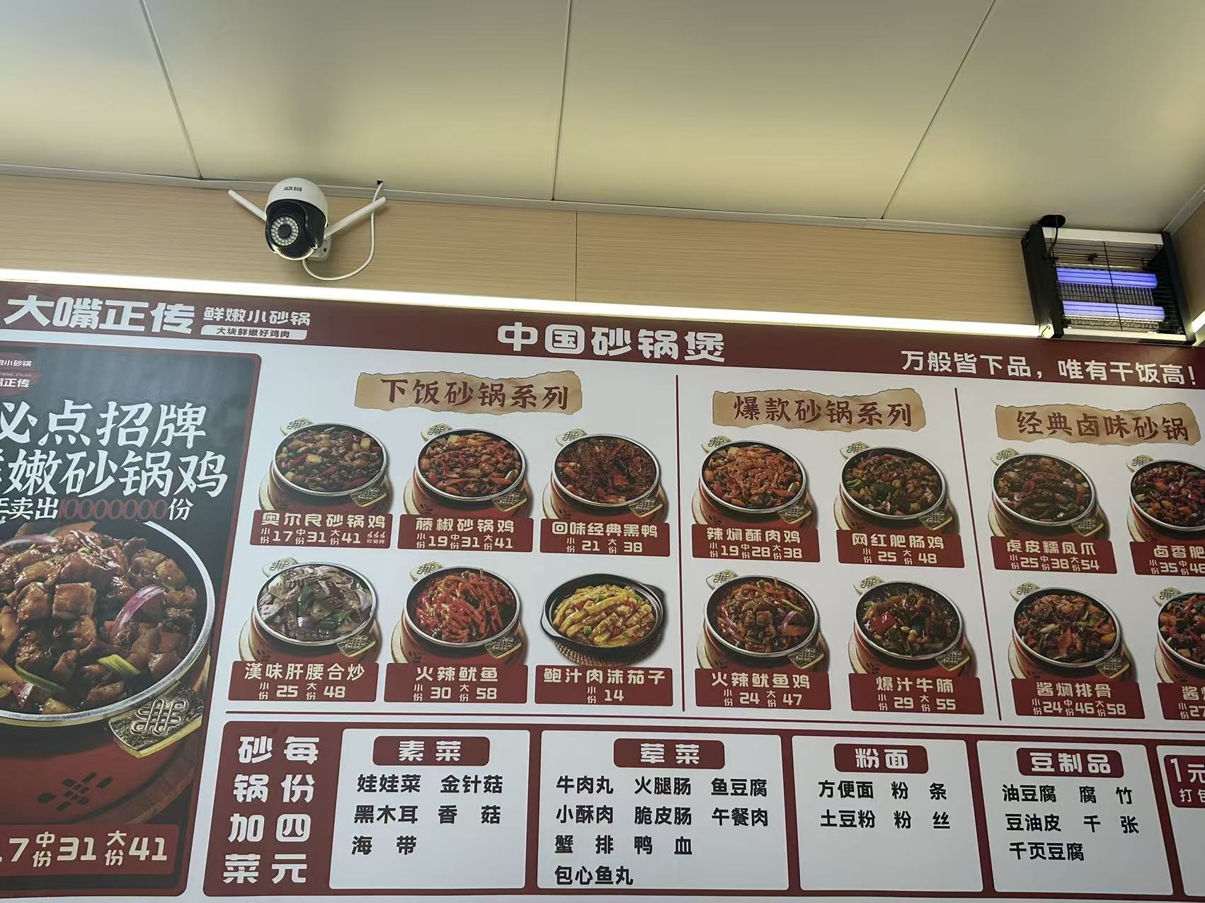Large in-store chicken pot menu board with many dish prices